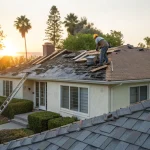 Workers replacing old shingles, a major factor in how much a new roof costs.