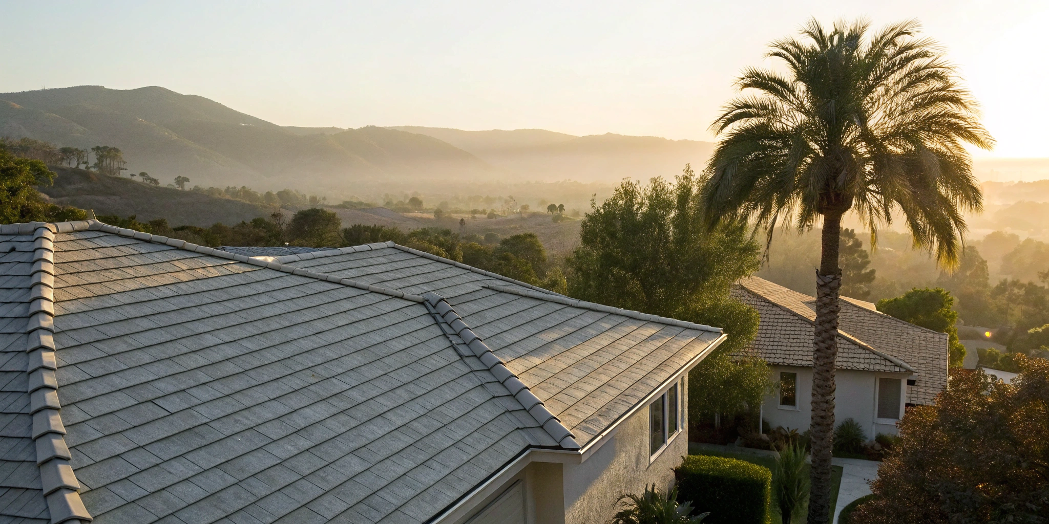 A residential tile roof at sunrise, a reminder to decide how often your roof needs maintenance.