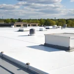 A commercial flat roof with a white membrane in need of professional repair.