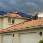 Roofers perform an emergency roof repair on a San Diego home under stormy skies.