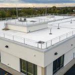 A secure flat roof with perimeter security fencing and rooftop equipment.
