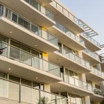 A licensed inspector checks a condo balcony for structural safety requirements in California.