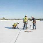 Professional roofing contractor inspecting a commercial flat roof in Southern California