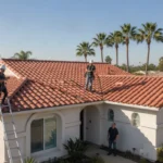 Southern California home with well-maintained red tile roof under blue sky with palm trees